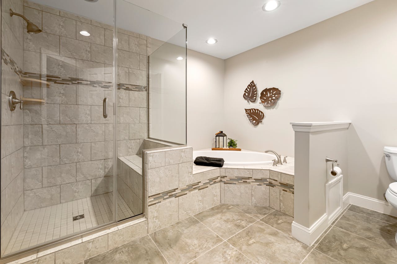 gallery-05 Spacious modern bathroom featuring a glass shower, tub, and stylish decor.